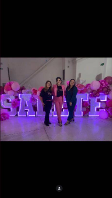Convidadas posando diante das letras iluminadas SALETE