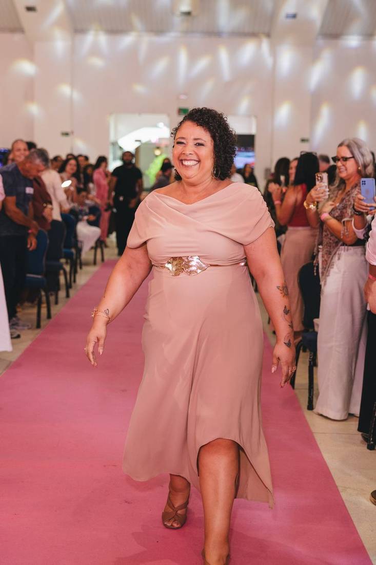 Mulher desfilando e sorrindo