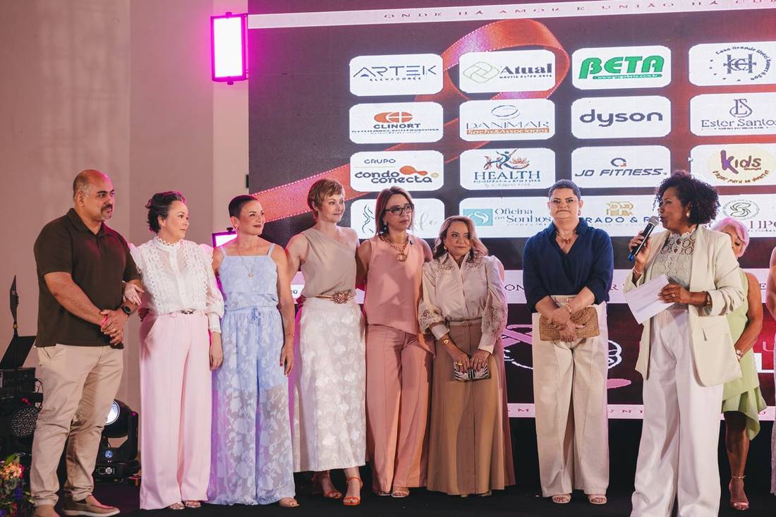 Grupo de mulheres do Calendário 2027 no painel dos patrocinadores